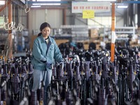 Workers rush to make Japanese-ordered products on the wheelchair production line of Zhongjin Medical Equipment Taizhou Co., Ltd. in Taizhou,...