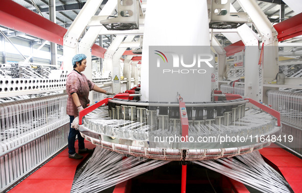 A worker works on the production line of a woven bag company in Lianyungang, China, on October 8, 2024. 