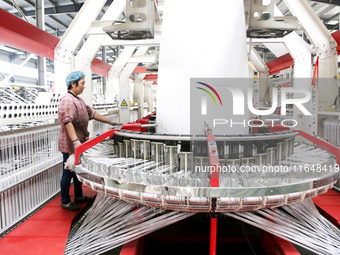 A worker works on the production line of a woven bag company in Lianyungang, China, on October 8, 2024. (