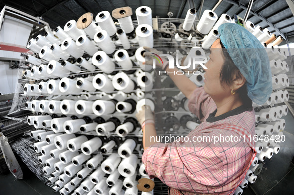 A worker works on the production line of a woven bag company in Lianyungang, China, on October 8, 2024. 