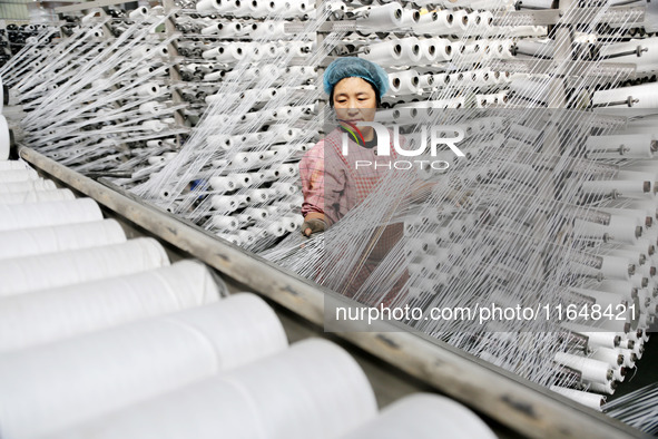 A worker works on the production line of a woven bag company in Lianyungang, China, on October 8, 2024. 