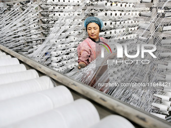 A worker works on the production line of a woven bag company in Lianyungang, China, on October 8, 2024. (