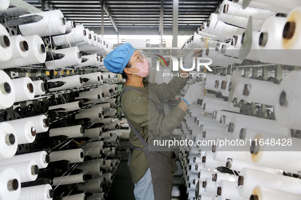 A worker works on the production line of a woven bag company in Lianyungang, China, on October 8, 2024. 