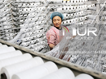 A worker works on the production line of a woven bag company in Lianyungang, China, on October 8, 2024. (