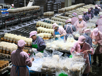 Workers pack golden mushrooms in a production workshop of Jiangsu Hualu Biotechnology Co LTD in Siyang National Modern Agriculture Industria...