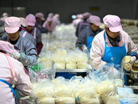 Workers pack golden mushrooms in a production workshop of Jiangsu Hualu Biotechnology Co LTD in Siyang National Modern Agriculture Industria...