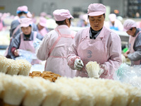 Workers pack golden mushrooms in a production workshop of Jiangsu Hualu Biotechnology Co LTD in Siyang National Modern Agriculture Industria...