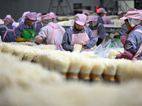 Workers pack golden mushrooms in a production workshop of Jiangsu Hualu Biotechnology Co LTD in Siyang National Modern Agriculture Industria...