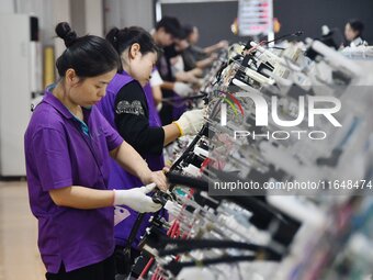 Workers work on a car harness production line at Handan Yongxu Automotive Electronics Co LTD in an industrial park in Yongnian district of H...