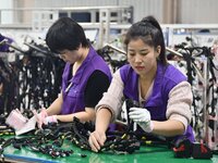 Workers work on a car harness production line at Handan Yongxu Automotive Electronics Co LTD in an industrial park in Yongnian district of H...