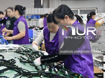 Workers work on a car harness production line at Handan Yongxu Automotive Electronics Co LTD in an industrial park in Yongnian district of H...