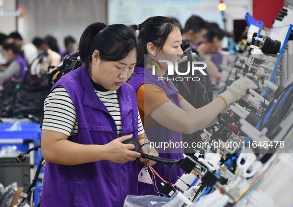 Workers work on a car harness production line at Handan Yongxu Automotive Electronics Co LTD in an industrial park in Yongnian district of H...