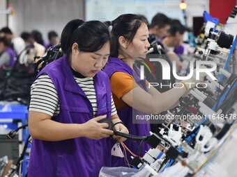 Workers work on a car harness production line at Handan Yongxu Automotive Electronics Co LTD in an industrial park in Yongnian district of H...