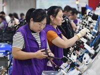 Workers work on a car harness production line at Handan Yongxu Automotive Electronics Co LTD in an industrial park in Yongnian district of H...