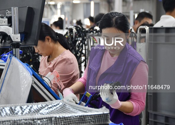 Workers work on a car harness production line at Handan Yongxu Automotive Electronics Co LTD in an industrial park in Yongnian district of H...