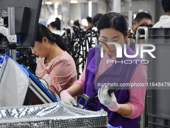 Workers work on a car harness production line at Handan Yongxu Automotive Electronics Co LTD in an industrial park in Yongnian district of H...