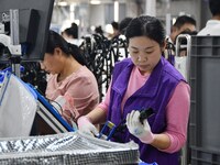 Workers work on a car harness production line at Handan Yongxu Automotive Electronics Co LTD in an industrial park in Yongnian district of H...