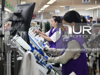 Workers work on a car harness production line at Handan Yongxu Automotive Electronics Co LTD in an industrial park in Yongnian district of H...