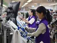 Workers work on a car harness production line at Handan Yongxu Automotive Electronics Co LTD in an industrial park in Yongnian district of H...