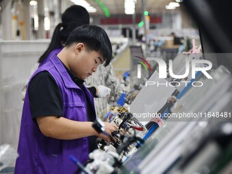 Workers work on a car harness production line at Handan Yongxu Automotive Electronics Co LTD in an industrial park in Yongnian district of H...