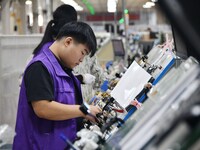 Workers work on a car harness production line at Handan Yongxu Automotive Electronics Co LTD in an industrial park in Yongnian district of H...