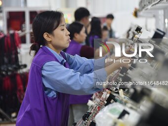 Workers work on a car harness production line at Handan Yongxu Automotive Electronics Co LTD in an industrial park in Yongnian district of H...