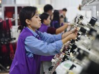 Workers work on a car harness production line at Handan Yongxu Automotive Electronics Co LTD in an industrial park in Yongnian district of H...