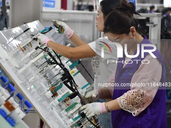 Workers work on a car harness production line at Handan Yongxu Automotive Electronics Co LTD in an industrial park in Yongnian district of H...