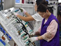 Workers work on a car harness production line at Handan Yongxu Automotive Electronics Co LTD in an industrial park in Yongnian district of H...