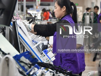 Workers work on a car harness production line at Handan Yongxu Automotive Electronics Co LTD in an industrial park in Yongnian district of H...