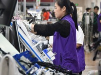 Workers work on a car harness production line at Handan Yongxu Automotive Electronics Co LTD in an industrial park in Yongnian district of H...