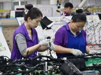 Workers work on a car harness production line at Handan Yongxu Automotive Electronics Co LTD in an industrial park in Yongnian district of H...