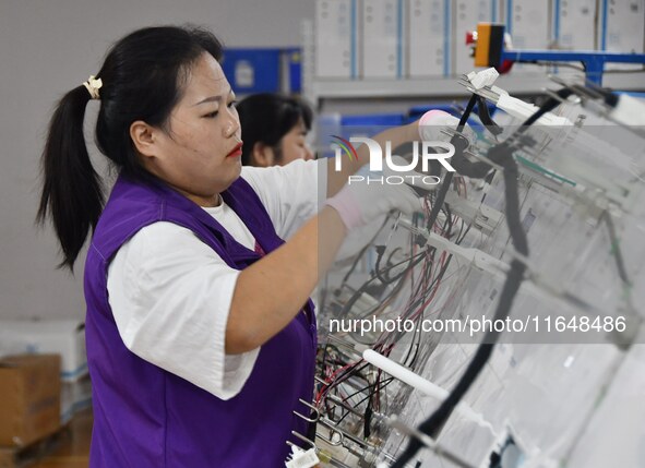 Workers work on a car harness production line at Handan Yongxu Automotive Electronics Co LTD in an industrial park in Yongnian district of H...