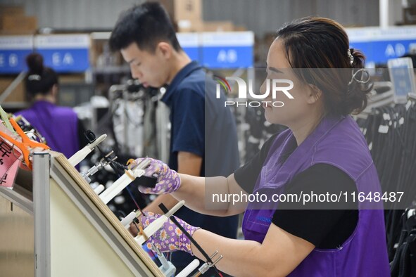 Workers work on a car harness production line at Handan Yongxu Automotive Electronics Co LTD in an industrial park in Yongnian district of H...