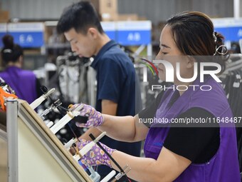 Workers work on a car harness production line at Handan Yongxu Automotive Electronics Co LTD in an industrial park in Yongnian district of H...