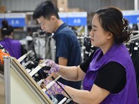 Workers work on a car harness production line at Handan Yongxu Automotive Electronics Co LTD in an industrial park in Yongnian district of H...