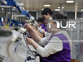 Workers work on a car harness production line at Handan Yongxu Automotive Electronics Co LTD in an industrial park in Yongnian district of H...