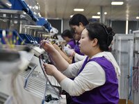 Workers work on a car harness production line at Handan Yongxu Automotive Electronics Co LTD in an industrial park in Yongnian district of H...