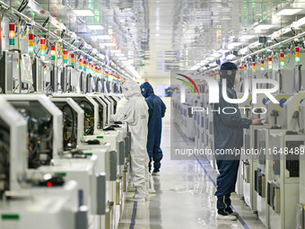 A worker works on an electronic component production line at Jiangsu Baopulai Semiconductor Co LTD in the Siyang Economic Development Zone i...