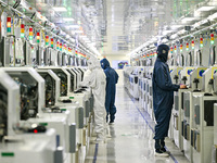 A worker works on an electronic component production line at Jiangsu Baopulai Semiconductor Co LTD in the Siyang Economic Development Zone i...