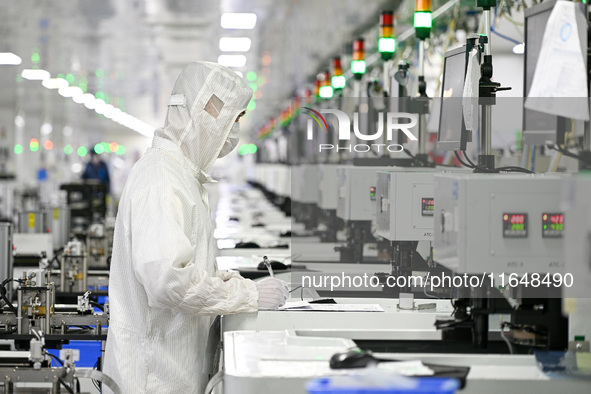 A worker works on an electronic component production line at Jiangsu Baopulai Semiconductor Co LTD in the Siyang Economic Development Zone i...