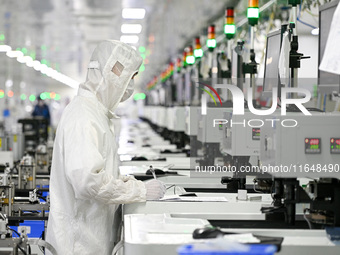 A worker works on an electronic component production line at Jiangsu Baopulai Semiconductor Co LTD in the Siyang Economic Development Zone i...