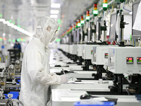 A worker works on an electronic component production line at Jiangsu Baopulai Semiconductor Co LTD in the Siyang Economic Development Zone i...