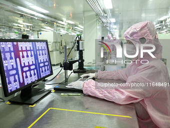 A worker works on an electronic component production line at Jiangsu Baopulai Semiconductor Co LTD in the Siyang Economic Development Zone i...