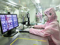 A worker works on an electronic component production line at Jiangsu Baopulai Semiconductor Co LTD in the Siyang Economic Development Zone i...