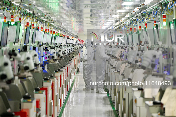 A worker works on an electronic component production line at Jiangsu Baopulai Semiconductor Co LTD in the Siyang Economic Development Zone i...