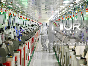 A worker works on an electronic component production line at Jiangsu Baopulai Semiconductor Co LTD in the Siyang Economic Development Zone i...