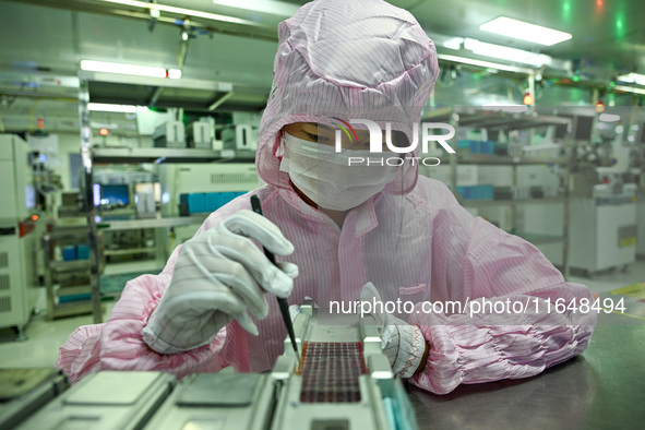 A worker works on an electronic component production line at Jiangsu Baopulai Semiconductor Co LTD in the Siyang Economic Development Zone i...