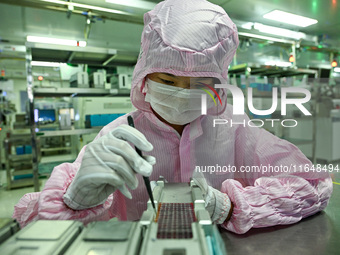 A worker works on an electronic component production line at Jiangsu Baopulai Semiconductor Co LTD in the Siyang Economic Development Zone i...