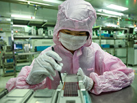 A worker works on an electronic component production line at Jiangsu Baopulai Semiconductor Co LTD in the Siyang Economic Development Zone i...